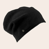 Black beanie hat on a beige background
