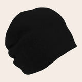 Black beanie hat on a beige background