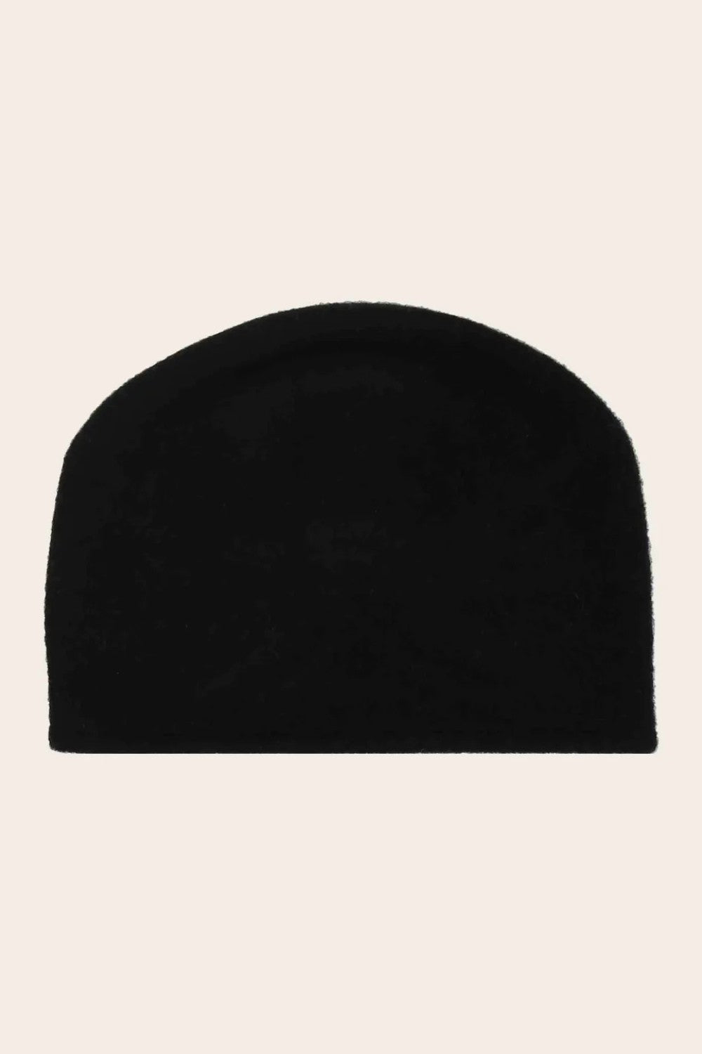 Black beanie hat on a beige background