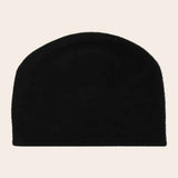 Black beanie hat on a beige background