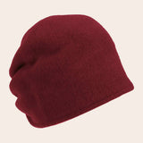 Burgundy beanie hat on a beige background