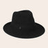 Black fedora hat on a beige background