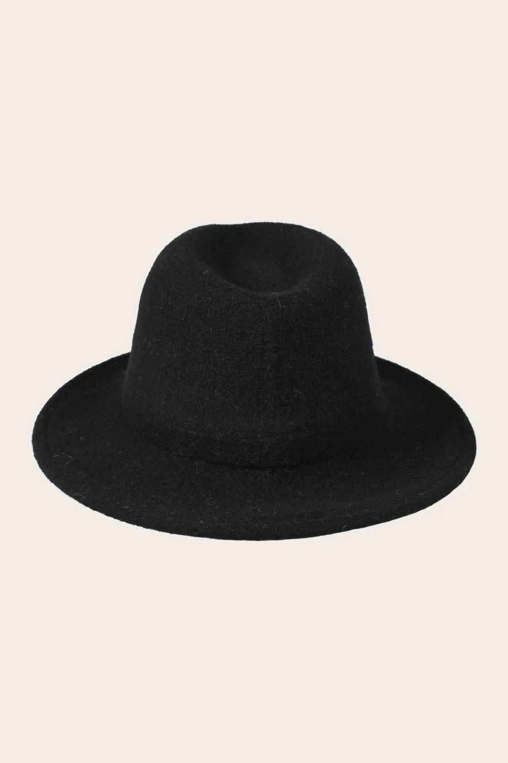 Black fedora hat on a beige background