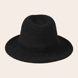 Black fedora hat on a beige background