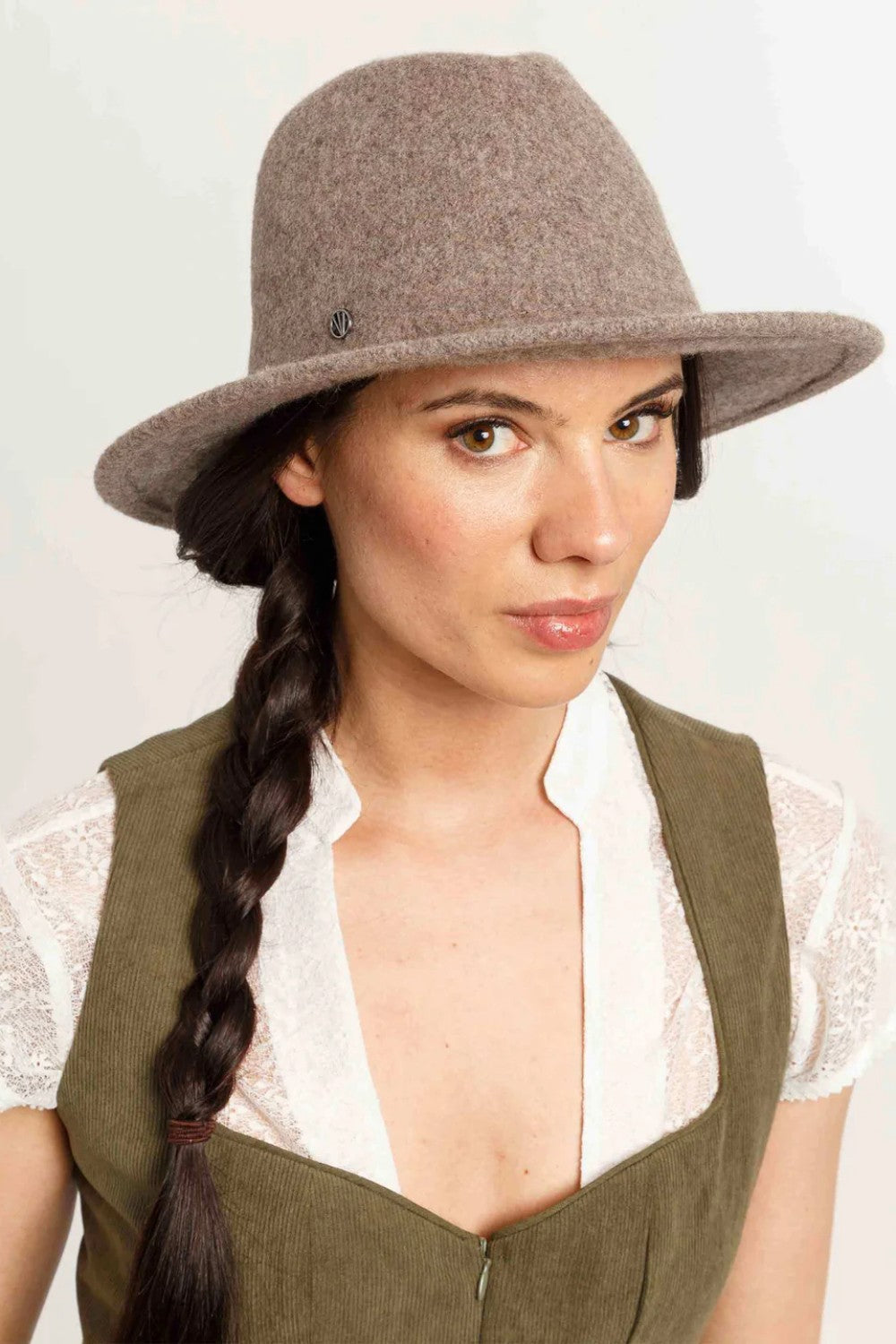 Woman wearing a brown hat with a plain background