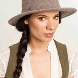 Woman wearing a brown hat with a plain background