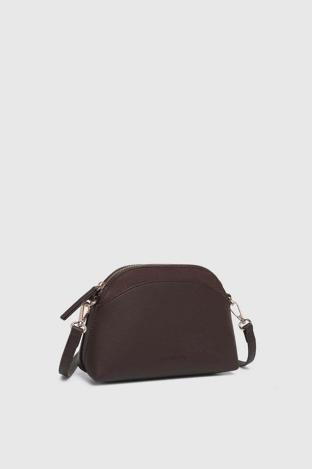 A dark brown pleather crescent-shaped shoulder bag with a matching zippered top and a thin shoulder strap, shown against a light gray background.