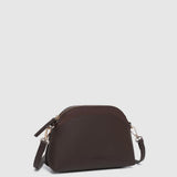 A dark brown pleather crescent-shaped shoulder bag with a matching zippered top and a thin shoulder strap, shown against a light gray background.