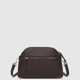 A dark brown pleather crossbody bag with an external zippered pocket and silver-tone hardware, shown against a light gray background.