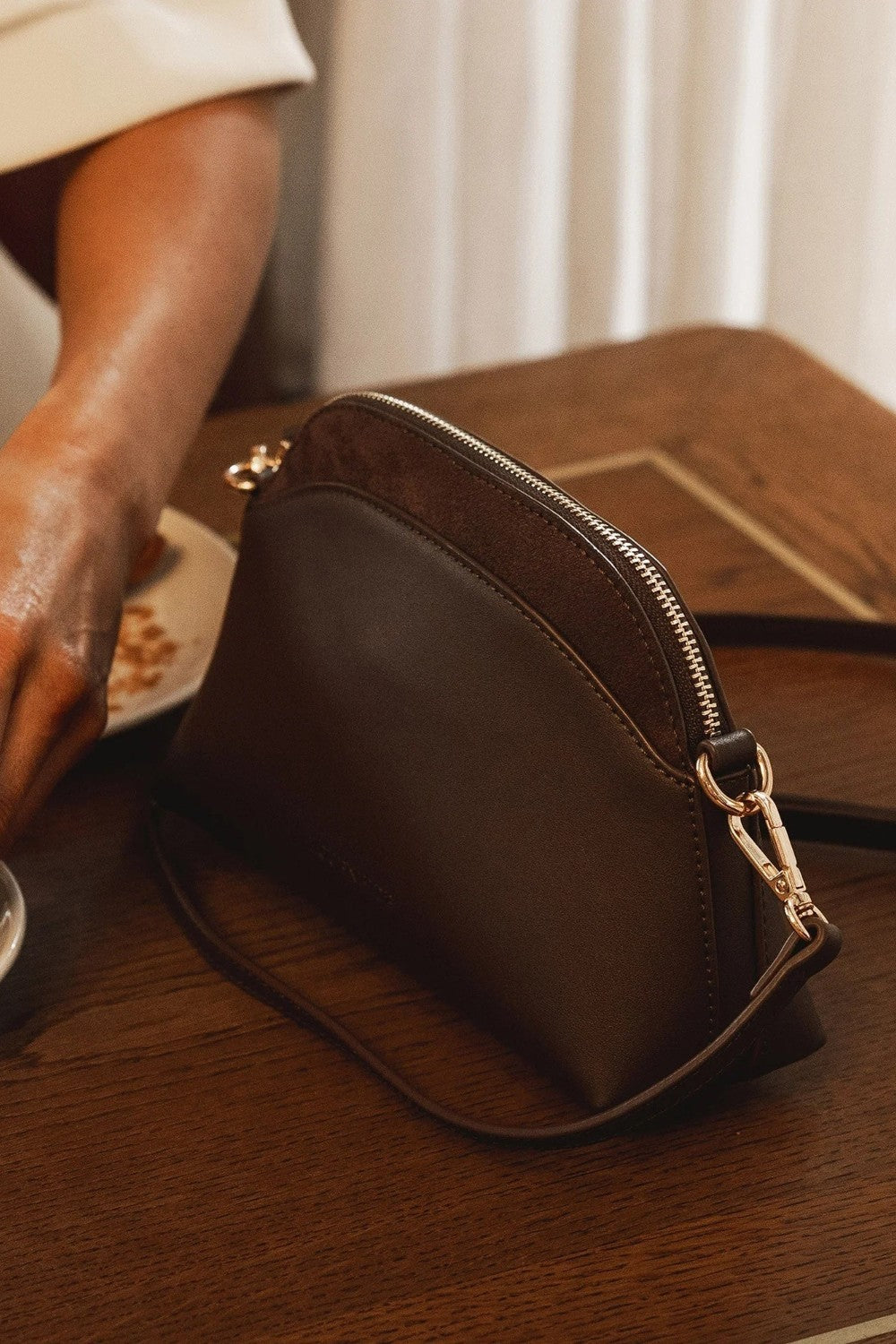Brown pleather bag on a wooden table with a blurred background