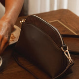 Brown pleather bag on a wooden table with a blurred background