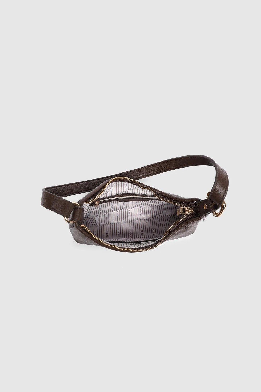 Brown leather bag with black and white striped lining and gold zipper on a light gray background