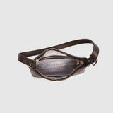 Brown leather bag with black and white striped lining and gold zipper on a light gray background