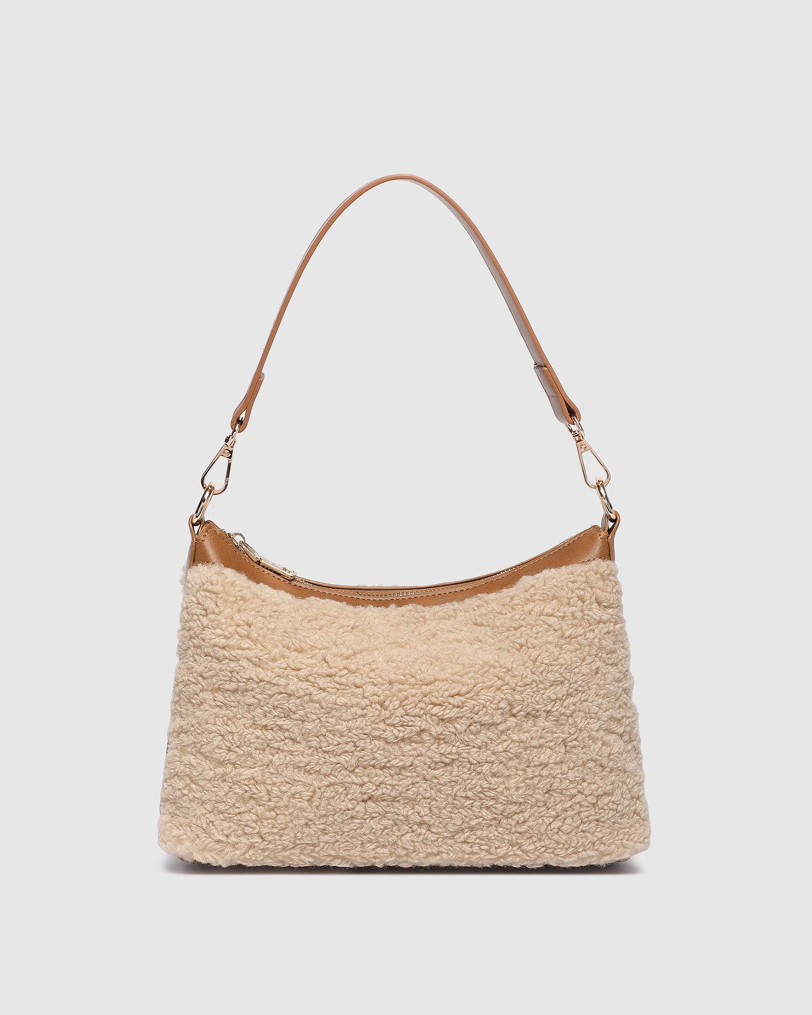 The Louenhide Aspen Shoulder Bag is the soft-structured silhouette your winter wardrobe’s been waiting for. Crafted in a faux shearling texture with warm neutral tones, this sherpa bag brings a subtle warmth to cool-weather dressing. Light gold hardware adds a refined touch to this beige shoulder bag, while the spacious interior easily fits your daily essentials. Whether styled with denim or layered with flowing silhouettes, the Aspen is designed to move with you through the season - statement, elevated, an
