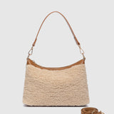 The Louenhide Aspen Shoulder Bag is the soft-structured silhouette your winter wardrobe’s been waiting for. Crafted in a faux shearling texture with warm neutral tones, this sherpa bag brings a subtle warmth to cool-weather dressing. Light gold hardware adds a refined touch to this beige shoulder bag, while the spacious interior easily fits your daily essentials. Whether styled with denim or layered with flowing silhouettes, the Aspen is designed to move with you through the season - statement, elevated, an