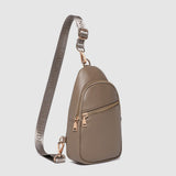 Beige crossbody bag with a strap on a light gray background