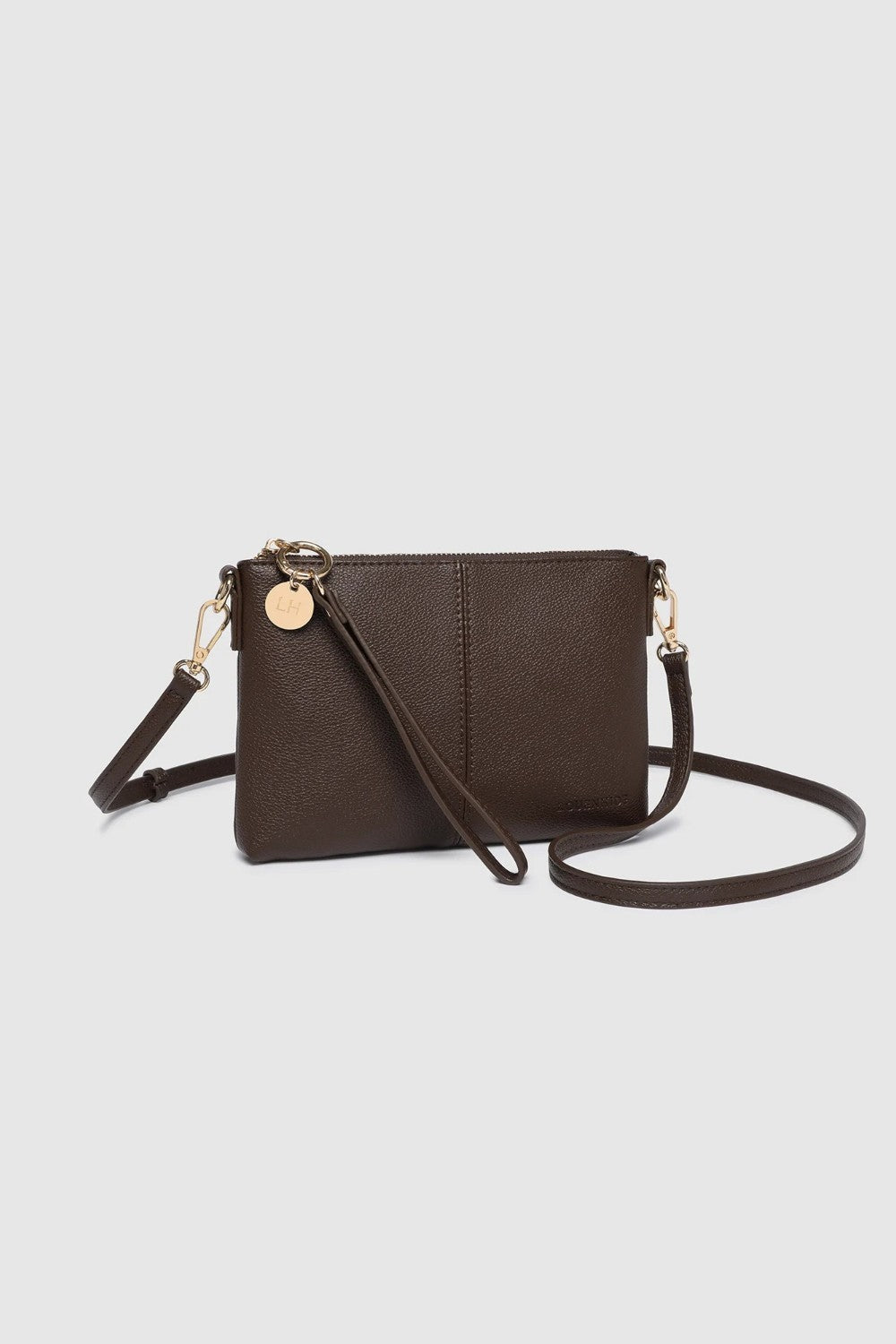A dark brown faux-leather crossbody bag with a matching wristlet strap and gold-tone hardware, displayed on a light gray background.