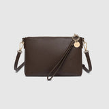 A dark brown faux-leather crossbody bag with a matching wristlet strap and gold-tone hardware, displayed on a light gray background.