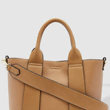 Tan handbag with a shoulder strap on a light gray background