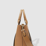 Tan handbag with a shoulder strap on a light gray background