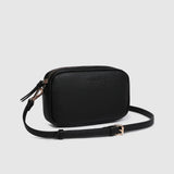 A black rectangular crossbody camera bag with a zippered top and an adjustable shoulder strap, shown on a light gray background.