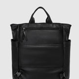 A black pebbled leather backpack with top handles, side pockets, and a front zippered pocket, shown against a light gray background.