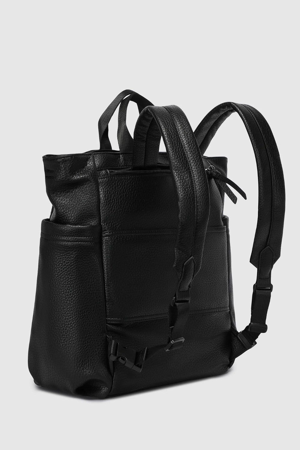 A black pebbled leather backpack with dual top handles and adjustable shoulder straps, shown from a three-quarter angle against a light gray background.
