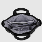 Top-down view of an open black handbag showing a gray and white striped interior lining, set against a light gray background.
