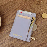 Lilac wallet with card slots and coins on a wooden surface