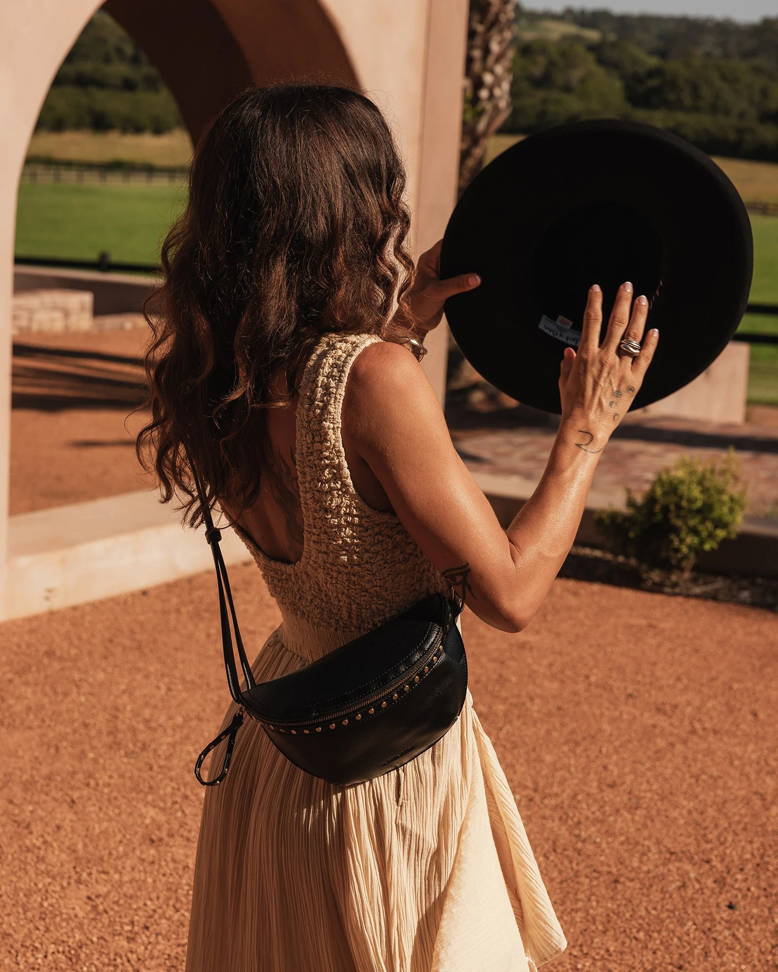 The Louenhide Cassidy Belt Bag is a bold staple designed to add a statement finish to your everyday styling. Crafted in a structured faux leather and adorned with refined hardware accents, this studded bag blends functionality with elevated design. The curved silhouette sits comfortably against the body, while the adjustable strap offers the option to wear it as a classic belt bag or crossbody style - making it one of the best sling bag options for hands-free ease. Compact yet roomy enough for your on-the-g