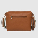 A brown faux-leather crossbody bag with a outside zip pocket, featuring a striped woven strap and a tassel detail, shown against a light gray background.