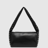 A black leather shoulder bag with a wide, studded strap, photographed against a solid light gray background.