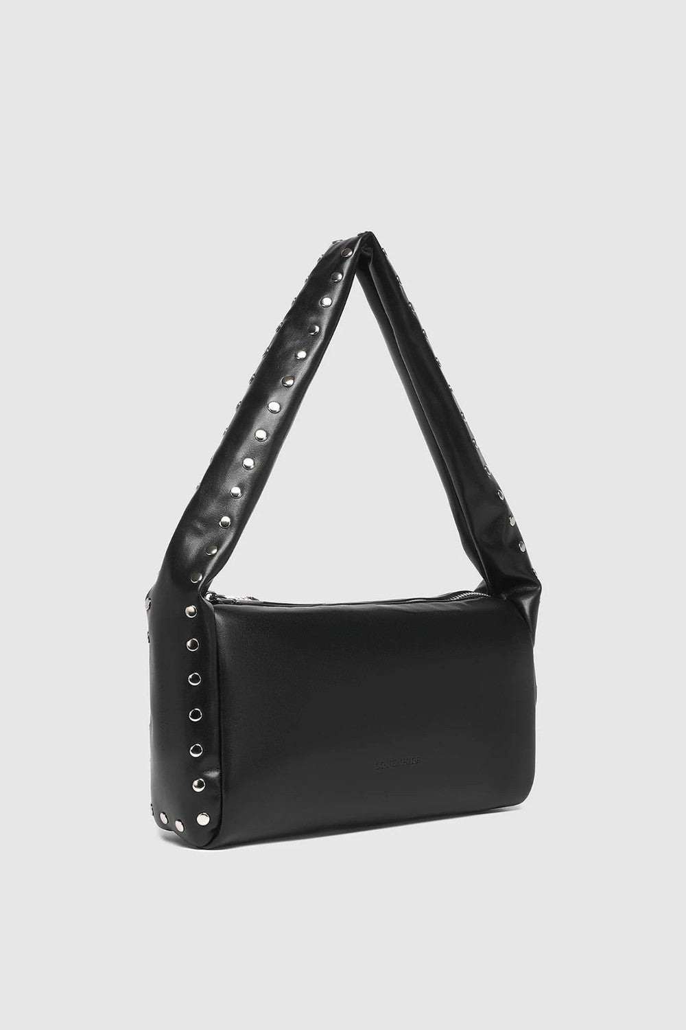 A black shoulder bag with a wide, triangular strap adorned with silver studs, shown against a light gray background.
