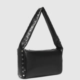 A black shoulder bag with a wide, triangular strap adorned with silver studs, shown against a light gray background.