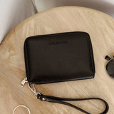 Black wallet with a strap on a wooden surface, featuring the brand 'Louenhide'.
