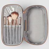 Makeup brushes in a striped case on a white background