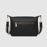 Black handbag with gold zipper on a light gray background