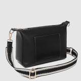 Black handbag with a strap on a light gray background