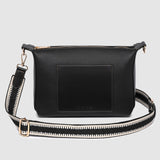 Black pleather crossbody bag with a strap on a light gray background