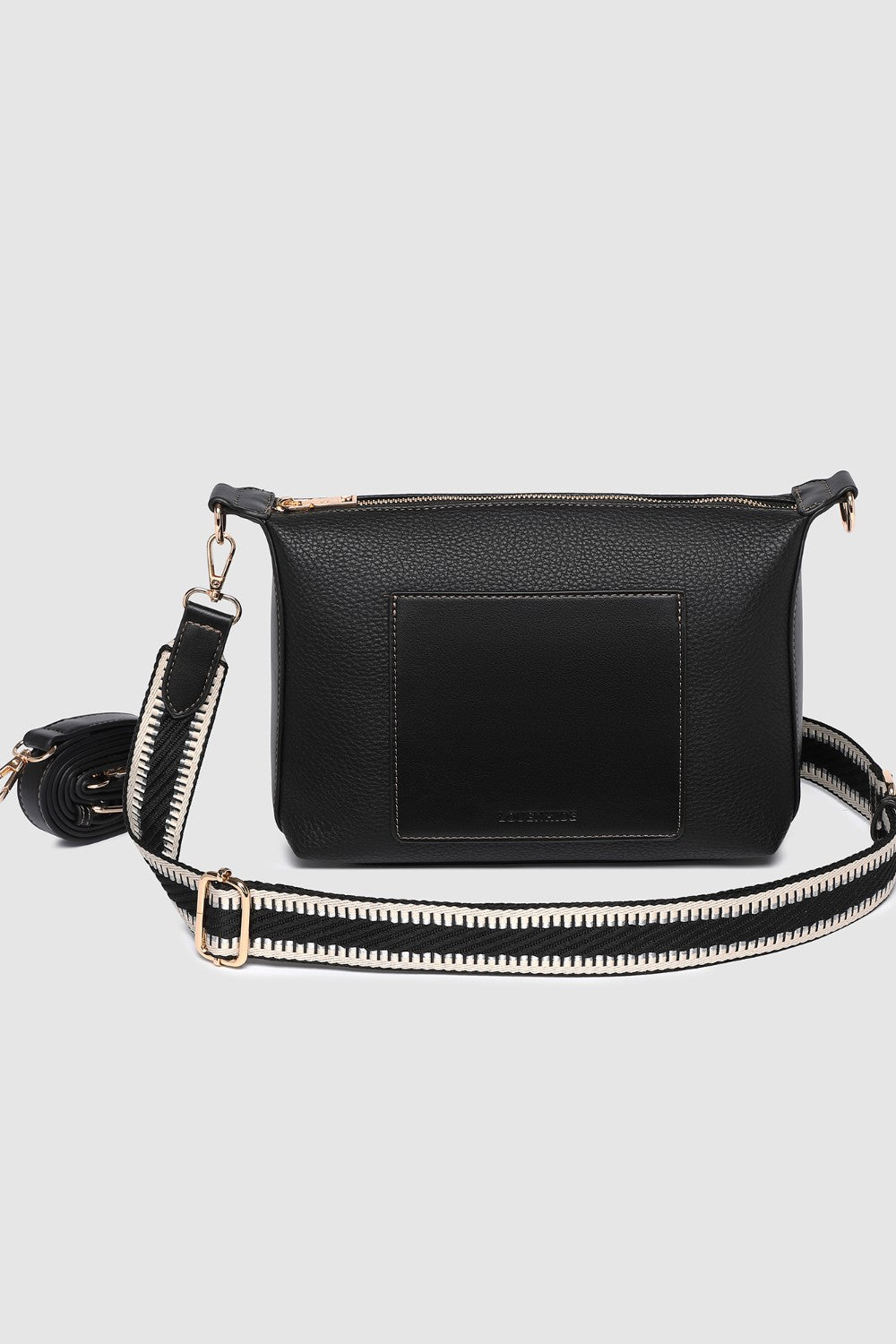 Black pleather crossbody bag with a strap on a light gray background