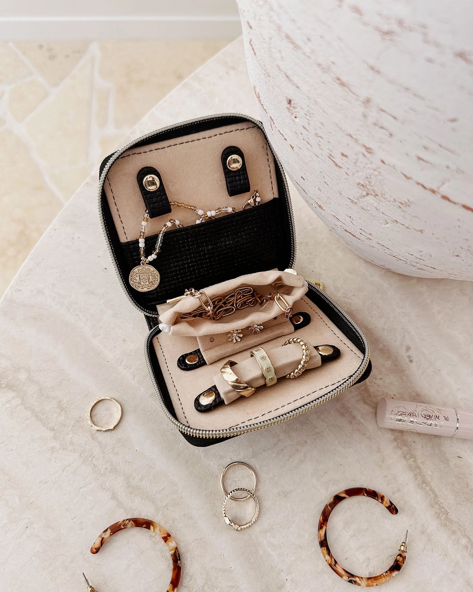 The Louenhide Juniper  Jewelry Case is ideal for those who appreciate the finer details in their jewelry storage. Designed with your dynamic lifestyle in mind, this jewellery wallet is compact and portable. Whether placed on your vanity at home or tucked into your luggage for travel, the Juniper ensures your favourite pieces are protected wherever you go. Organize your pieces with the two press stud hooks, slip pocket, drawstring bag, ring roll and earring press stud band. Structured and protected, th