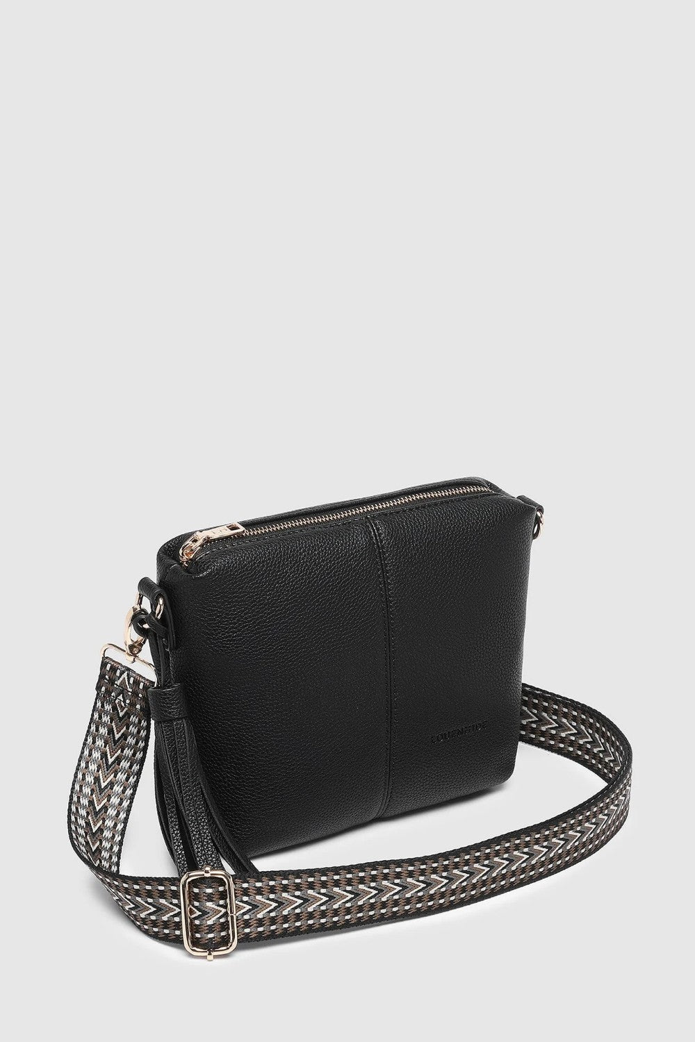 A black pebbled leather crossbody bag with a woven black and silver patterned shoulder strap and silver-tone hardware, shown on a light gray background.