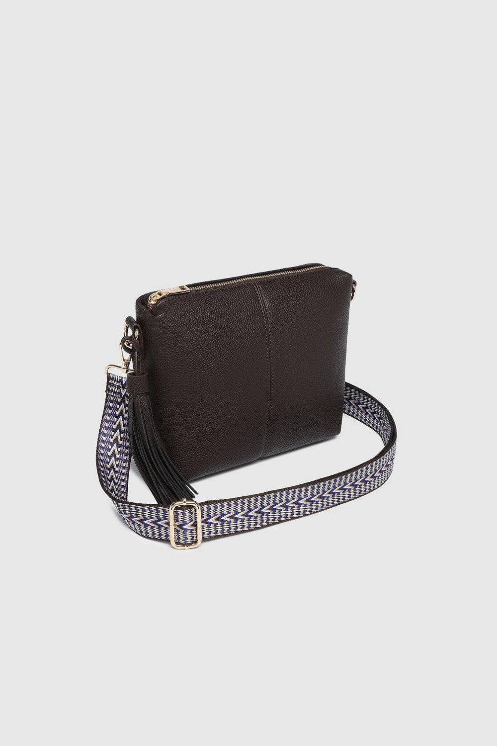 A dark brown leather crossbody bag with a patterned woven strap featuring a gold-tone buckle, shown on a light gray background.