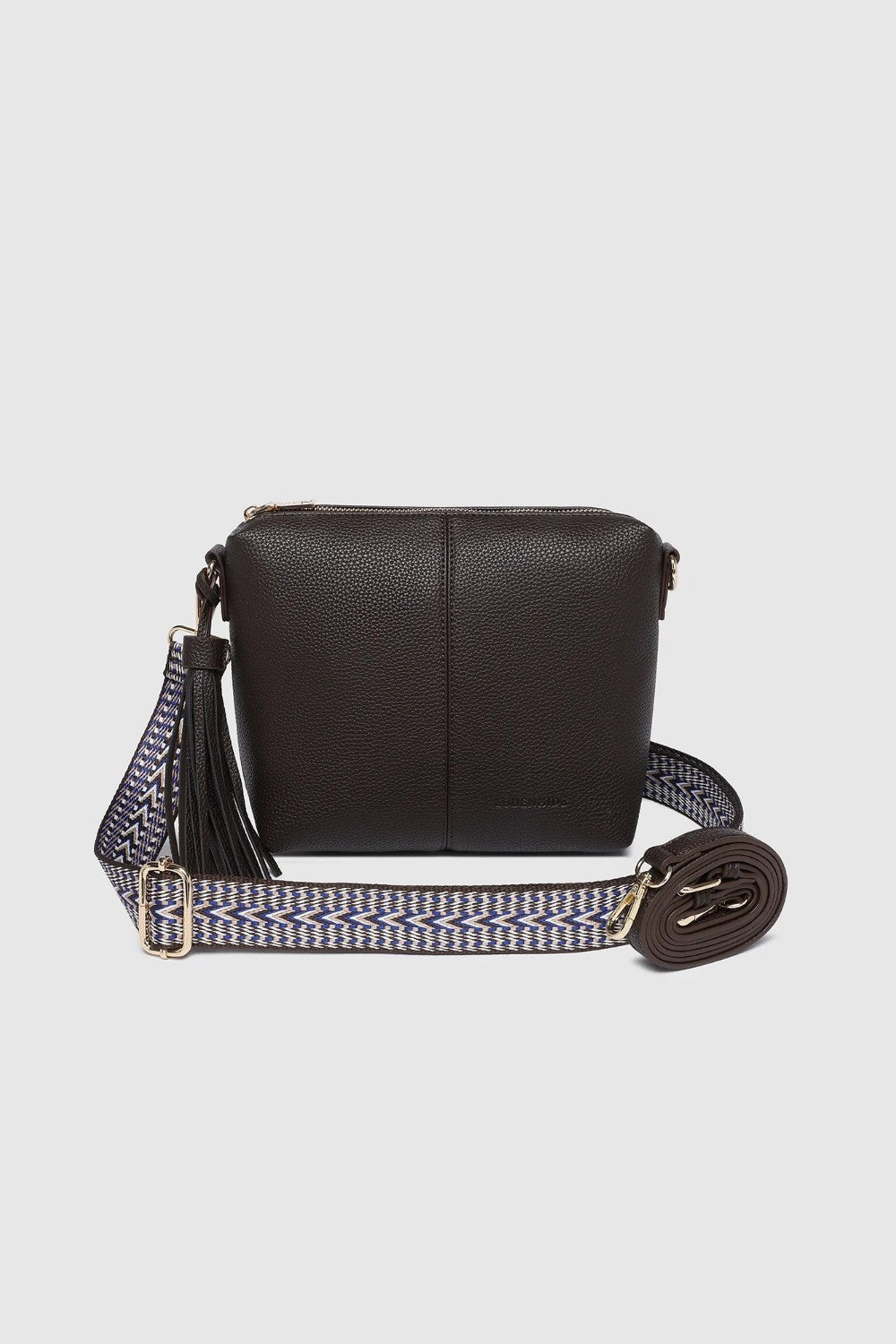 A dark brown pebbled pleather crossbody bag with a patterned woven strap, a separate thinner pleather strap, and gold-tone hardware, shown against a light gray background.