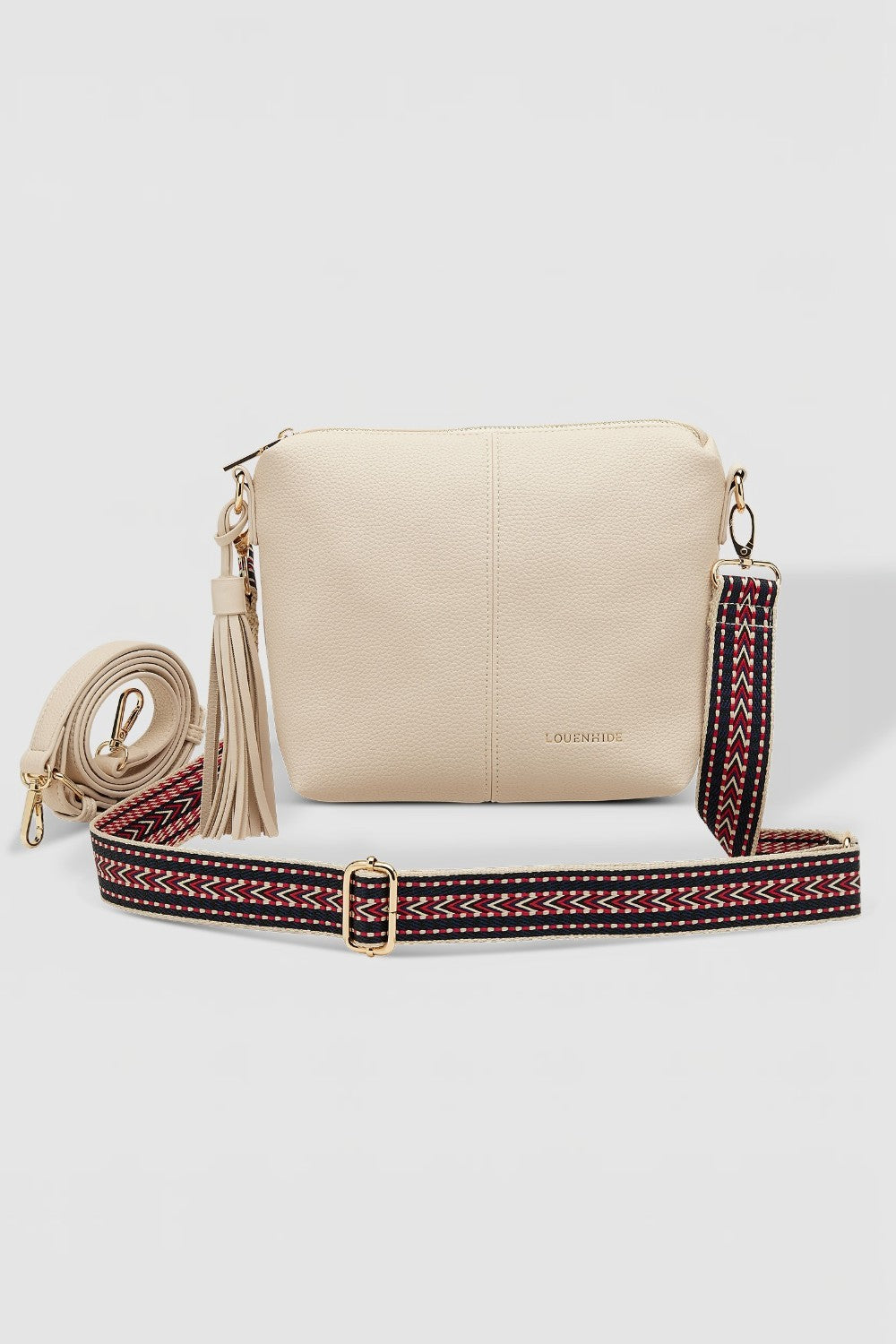 Beige handbag with a strap featuring red and black patterns on a light gray background