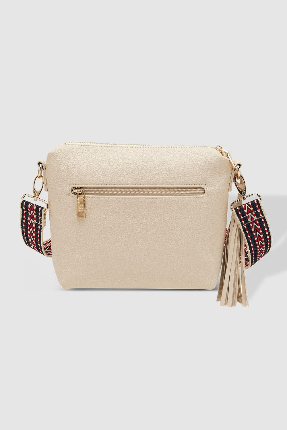 Beige handbag with colorful strap and tassel on a white background