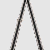 Black and white striped bag strap on a light gray background