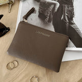 Brown pleather pouch with 'LOUENHIDE' branding on a wooden surface with keys and rings.