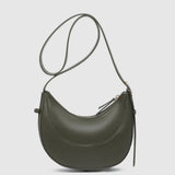 An olive green crescent-shaped leather shoulder bag with a thin matching shoulder strap and gold-tone hardware, shown against a light gray background.