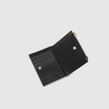 A black leather card holder with a gold-tone zipper pull, shown against a light gray background.